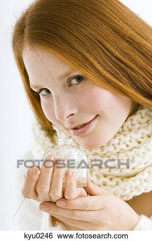 Stock Photograph - Portrait of a young woman smelling perfume. Fotosearch