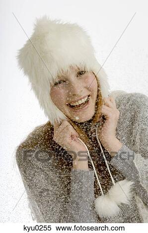 Stock Photography - Portrait of a young woman smiling during snowing. Fotosearch