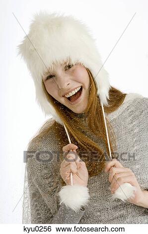 Stock Photograph - Portrait of a young woman wearing a fur hat and smiling. Fotosearch