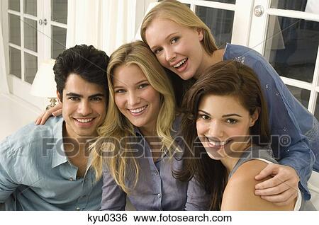 Stock Photograph - Portrait of four friends smiling. Fotosearch