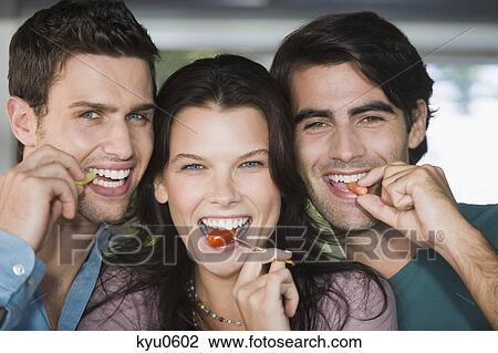 Portrait of three friends eating fruits View Large Photo Image Stock Image - Portrait of three friends eating fruits. Fotosearch