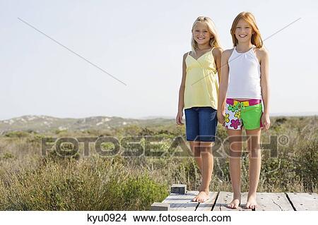 Portrait of two girls standing on a boardwalk View Large Photo Image Picture - Portrait of two girls standing on a boardwalk. Fotosearch