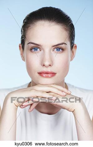 Portrait of young woman with hands on chin View Large Photo Image Stock Photograph - Portrait of young woman with hands on chin. Fotosearch