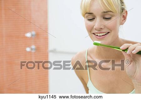 Reflection of a woman in the mirror holding a toothbrush View Large Photo Image Stock Photography - Reflection of a woman in the mirror holding a toothbrush. Fotosearch
