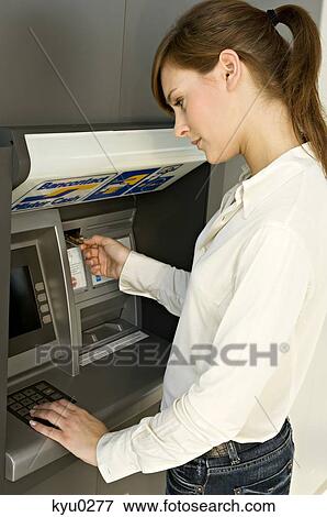 Side profile of a businesswoman using an ATM View Large Photo Image Stock Photo - Side profile of a businesswoman using an ATM. Fotosearch