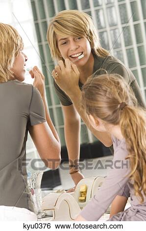 Teenage boy brushing his teeth with his sister looking at him View Large Photo Image Stock Photograph - Teenage boy brushing his teeth with his sister looking at him. Fotosearch