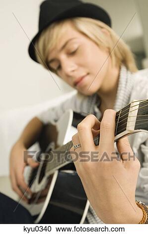 Teenage boy playing a guitar View Large Photo Image Stock Image - Teenage boy playing a guitar. Fotosearch