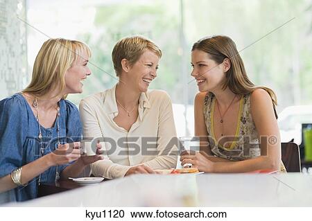 Stock Image - Three women sitting in a restaurant. Fotosearch