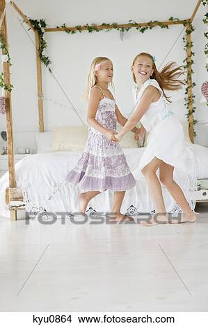 Two flower girls playing in a bedroom View Large Photo Image Picture - Two flower girls playing in a bedroom. Fotosearch