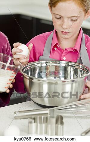 Two girls cooking food in the kitchen View Large Photo Image Stock Photograph - Two girls cooking food in the kitchen. Fotosearch