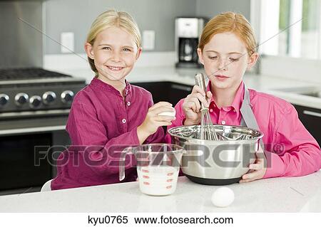 Two girls cooking food in the kitchen View Large Photo Image Stock Photography - Two girls cooking food in the kitchen. Fotosearch