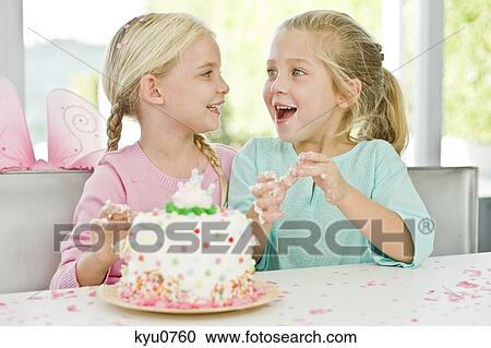 Stock Image - Two girls enjoying a birthday party. Fotosearch
