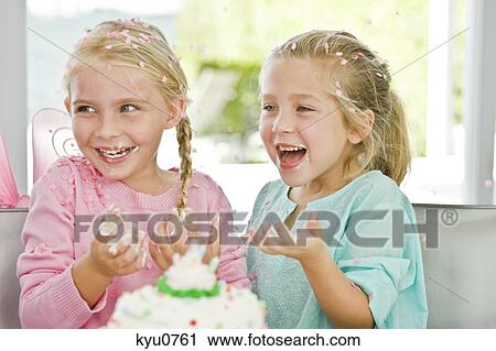 Stock Image - Two girls enjoying a birthday party. Fotosearch