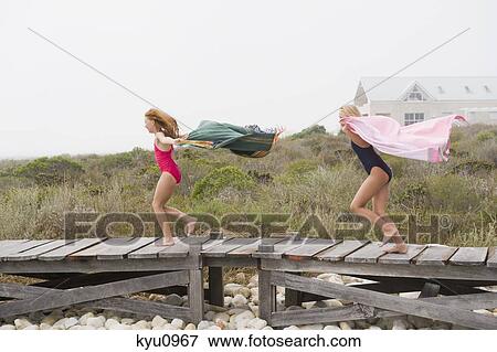 Two girls running on a boardwalk View Large Photo Image Stock Photo - Two girls running on a boardwalk. Fotosearch