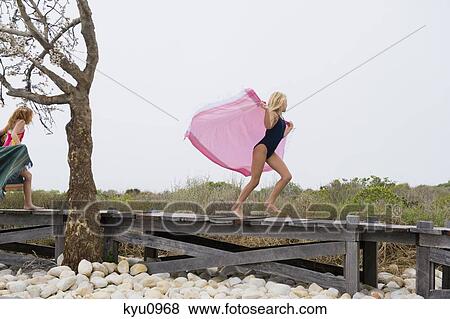 Two girls running on a boardwalk View Large Photo Image Stock Photo - Two girls running on a boardwalk. Fotosearch