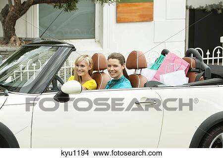 Two women smiling in a car after shopping View Large Photo Image Picture - Two women smiling in a car after shopping. Fotosearch