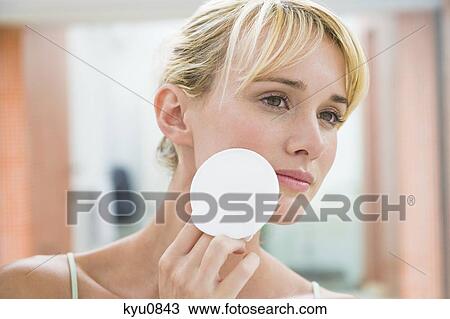 Stock Image - Woman applying face powder. Fotosearch