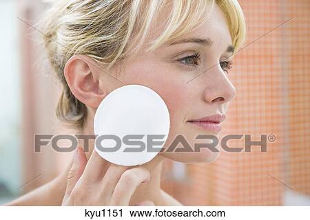 Stock Image - Woman applying face powder. Fotosearch