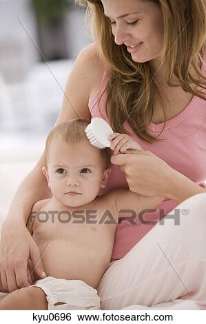 Woman brushing her daughter's hair View Large Photo Image Stock Photograph - Woman brushing her daughter's hair. Fotosearch