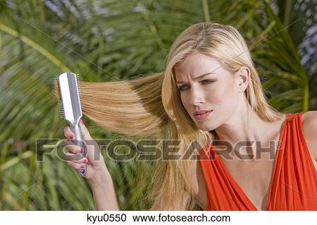 Stock Image - Woman brushing her hair. Fotosearch