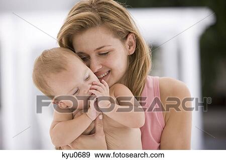 Stock Photo - Woman carrying her daughter. Fotosearch