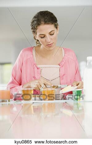 Woman having breakfast at a table View Large Photo Image Stock Photography - Woman having breakfast at a table. Fotosearch
