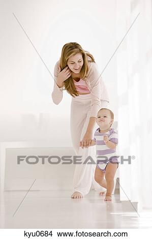 Picture - Woman helping her daughter to walk. Fotosearch