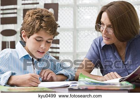 Woman helping her grandson in homework View Large Photo Image Stock Photo - Woman helping her grandson in homework. Fotosearch
