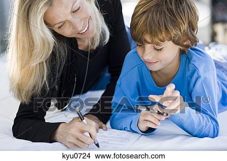 Woman helping her son in his homework View Large Photo Image Picture - Woman helping her son in his homework. Fotosearch