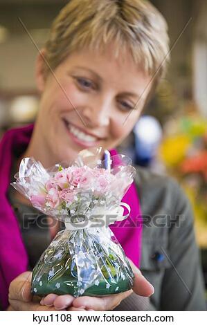 Woman holding a bouquet of flowers and smiling View Large Photo Image Stock Photo - Woman holding a bouquet of flowers and smiling. Fotosearch