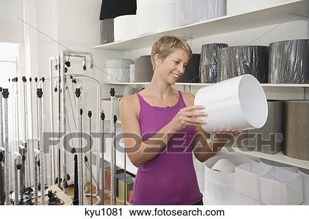 Woman holding a lampshade in a store View Large Photo Image Stock Image - Woman holding a lampshade in a store. Fotosearch
