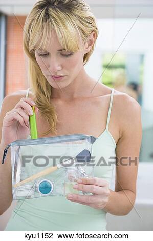 Stock Image - Woman holding a make-up bag. Fotosearch