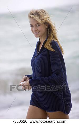 Woman holding a shell on the beach View Large Photo Image Stock Photograph - Woman holding a shell on the beach. Fotosearch