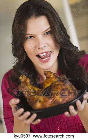 Woman holding a tray of roasted chicken View Large Photo Image Stock Photo - Woman holding a tray of roasted chicken. Fotosearch