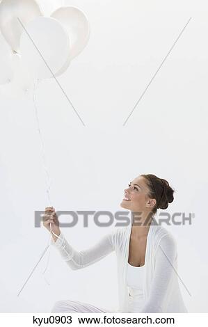 Woman holding balloons and smiling View Large Photo Image Stock Image - Woman holding balloons and smiling. Fotosearch