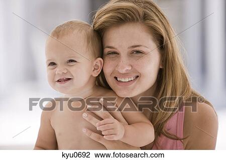 Woman holding her daughter View Large Photo Image Stock Image - Woman holding her daughter. Fotosearch