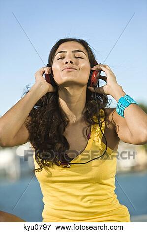 Woman listening to headphones View Large Photo Image Stock Photo - Woman listening to headphones. Fotosearch