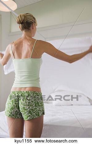 Woman making a bed View Large Photo Image Stock Photography - Woman making a bed. Fotosearch