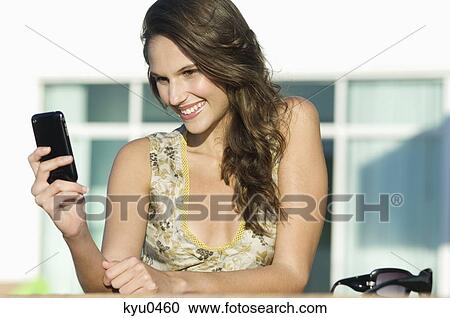 Woman reading text message on a mobile phone View Large Photo Image Stock Image - Woman reading text message on a mobile phone. Fotosearch