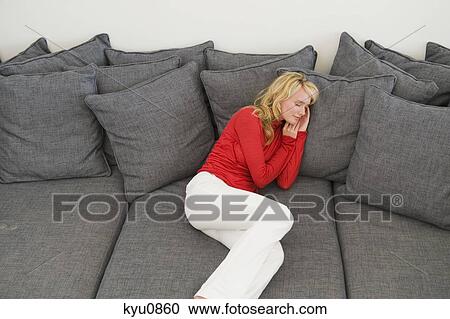 Stock Image - Woman reclining on a couch. Fotosearch