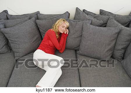 Stock Photo - Woman reclining on a couch. Fotosearch