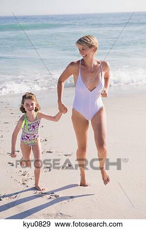 Woman running on the beach with her daughter View Large Photo Image Stock Photo - Woman running on the beach with her daughter. Fotosearch