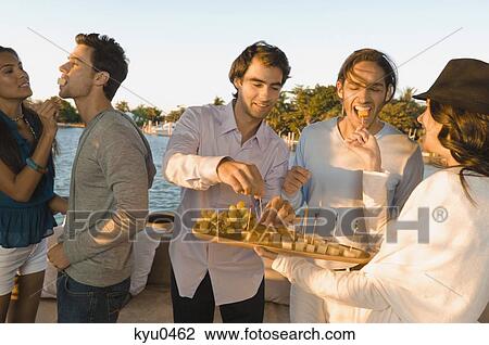 Woman serving fruits to her friends View Large Photo Image Stock Image - Woman serving fruits to her friends. Fotosearch