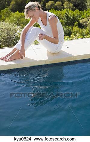 Woman sitting at the poolside View Large Photo Image Picture - Woman sitting at the poolside. Fotosearch