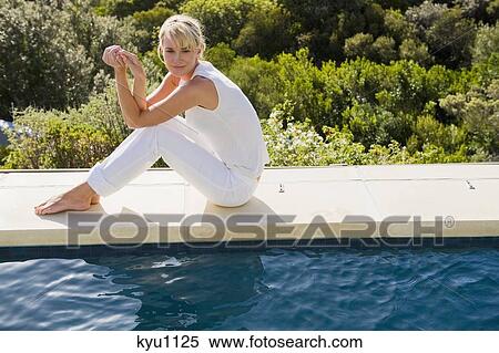 Woman sitting at the poolside View Large Photo Image Stock Photography - Woman sitting at the poolside. Fotosearch