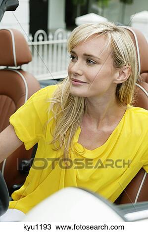 Woman sitting in a car and smiling View Large Photo Image Stock Image - Woman sitting in a car and smiling. Fotosearch