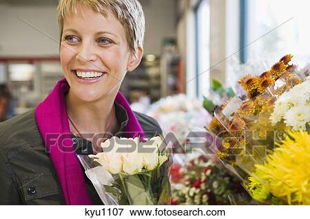 Woman smiling in a florist shop View Large Photo Image Stock Photo - Woman smiling in a florist shop. Fotosearch