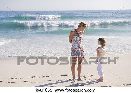 Woman standing on the beach with her daughter View Large Photo Image Stock Photography - Woman standing on the beach with her daughter. Fotosearch