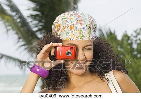 Stock Photo - Woman taking a picture with a digital camera. Fotosearch