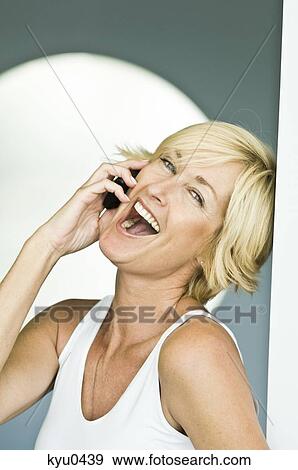 Woman talking on a mobile phone and laughing View Large Photo Image Stock Photo - Woman talking on a mobile phone and laughing. Fotosearch